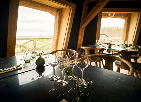 Ein urig gemütlicher Raum mit gedecktem Tisch und zwei Fenstern